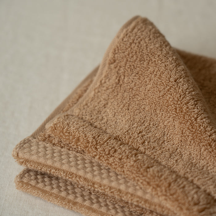 Folded brown towel on a neutral background
