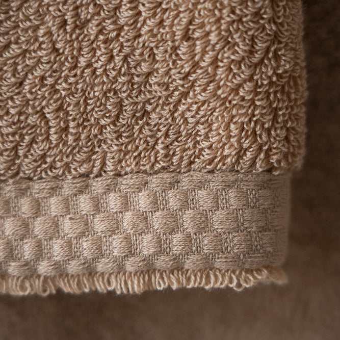 Close-up of a beige textured towel on a neutral background