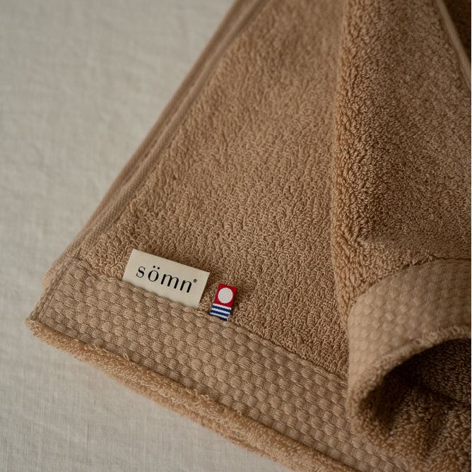 Brown towel with a label on a light background