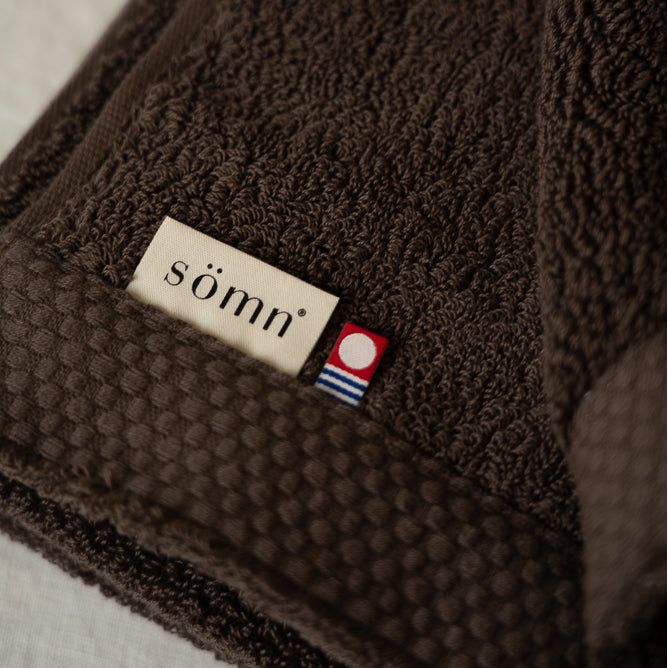Brown textured fabric with a 'somn' label on a neutral background