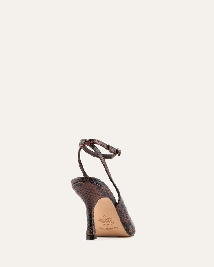 Brown high-heeled sandal with a strap on a light beige background