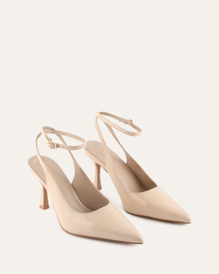 Pair of beige high-heeled shoes on a light background