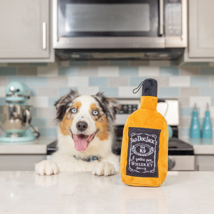 Dog with Bad Dog Jack plush toy in a kitchen featuring Bad Dog Jack's Whiskey.