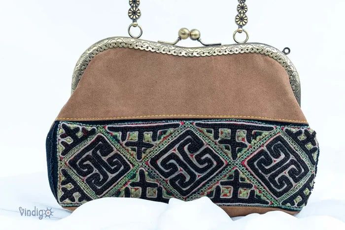 Close-up of brown suede handbag with geometric vintage embroidery