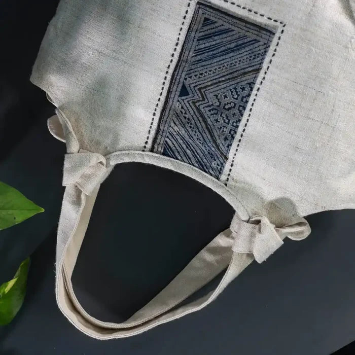 Natural hemp handbag with bamboo handle, side view showing batik patch design