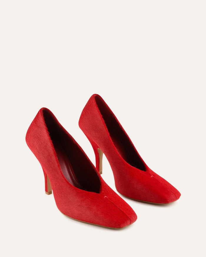 Pair of red high-heeled shoes on a white background