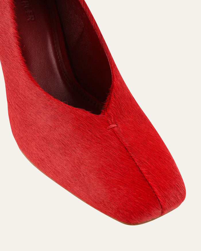 Red high-heeled shoe on a light gray background