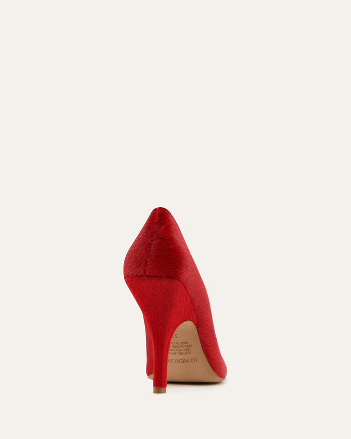 Red high-heeled shoe on a light beige background