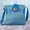 Vindigo blue embroidered crossbody bag front view with H’mong motifs and coconut button