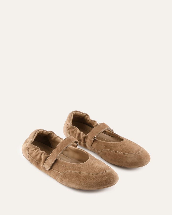 Pair of brown slippers with a strap on a white background