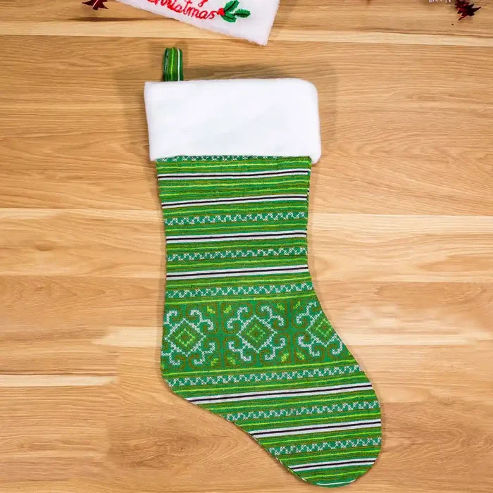 Vindigo green hand-embroidered Christmas stocking front angle wooden background