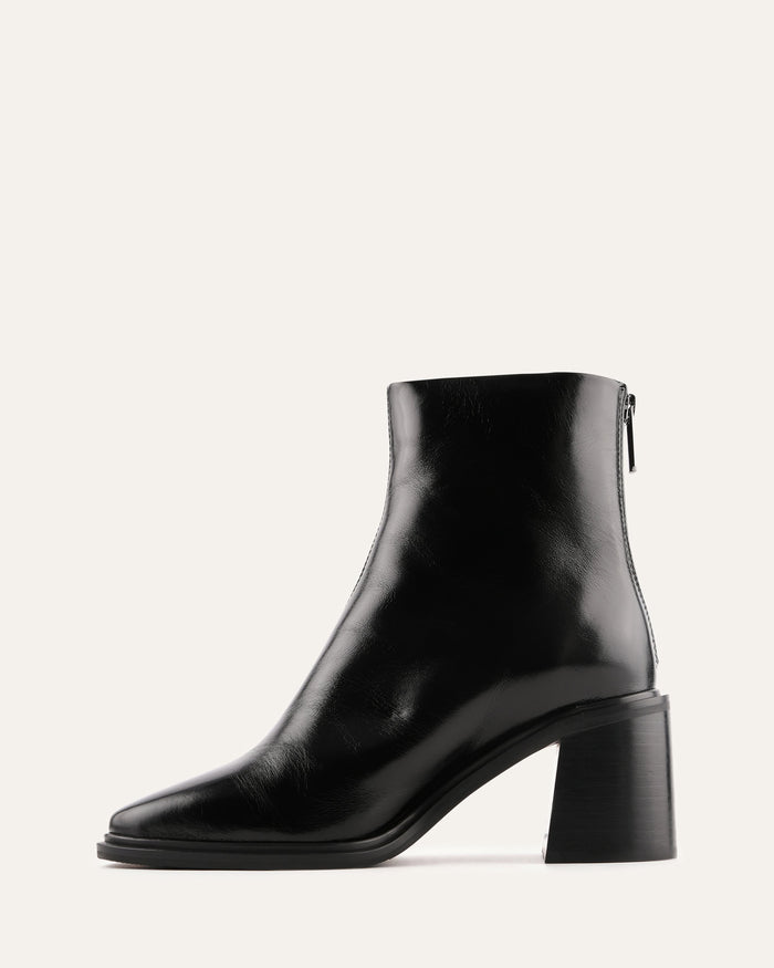 Black ankle boot with a block heel on a white background
