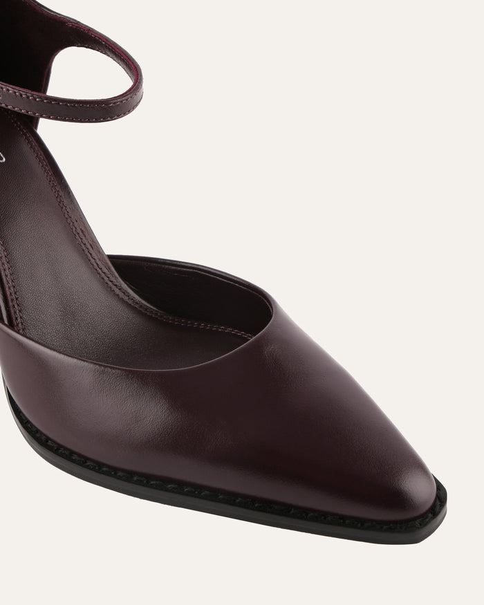 Brown pointed-toe shoe with a slingback design on a white background
