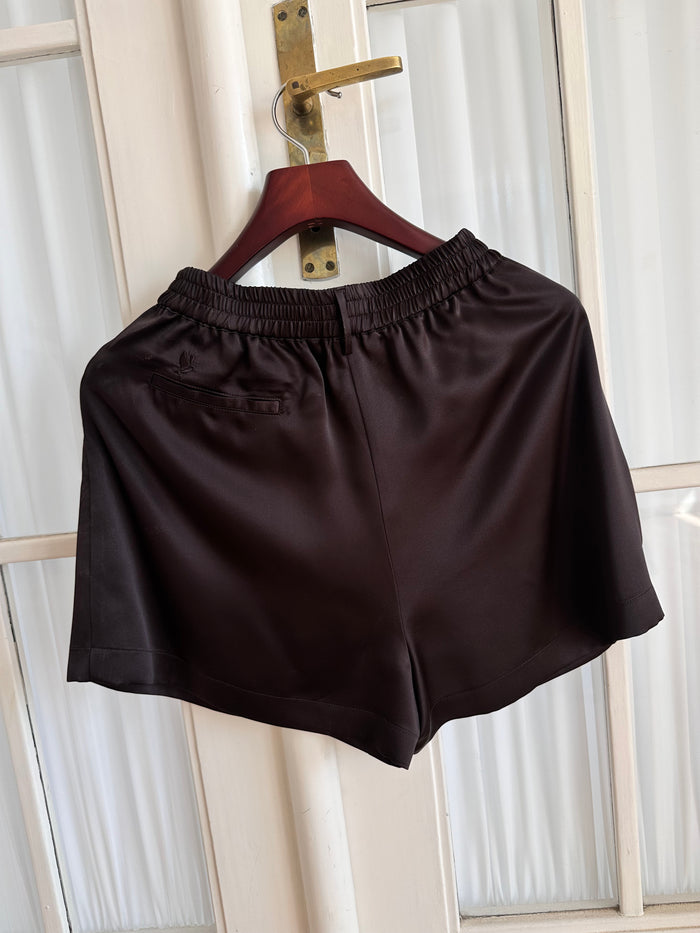 Core Edit Dark Chocolate Lounge Shorts hanging on a hanger, back view.