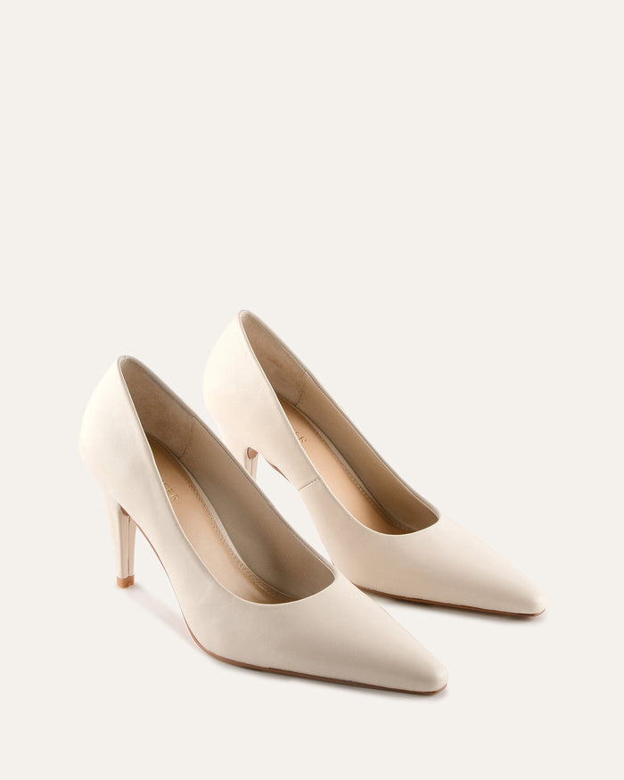 Pair of white high-heeled shoes on a light gray background