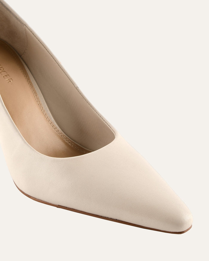 White high-heeled shoe on a light gray background