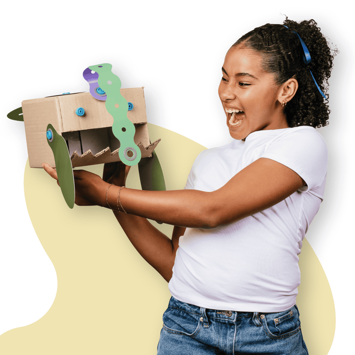 Makedo Deco-Props Blobbies cardboard creation with girl who looks excited about what she has made.
