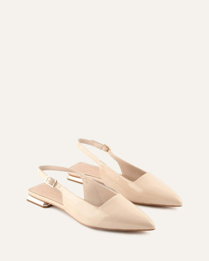 Pair of beige slingback flats on a white background