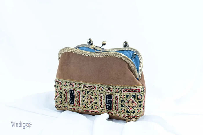 Vindigo handbag side view with curved copper frame and embroidery