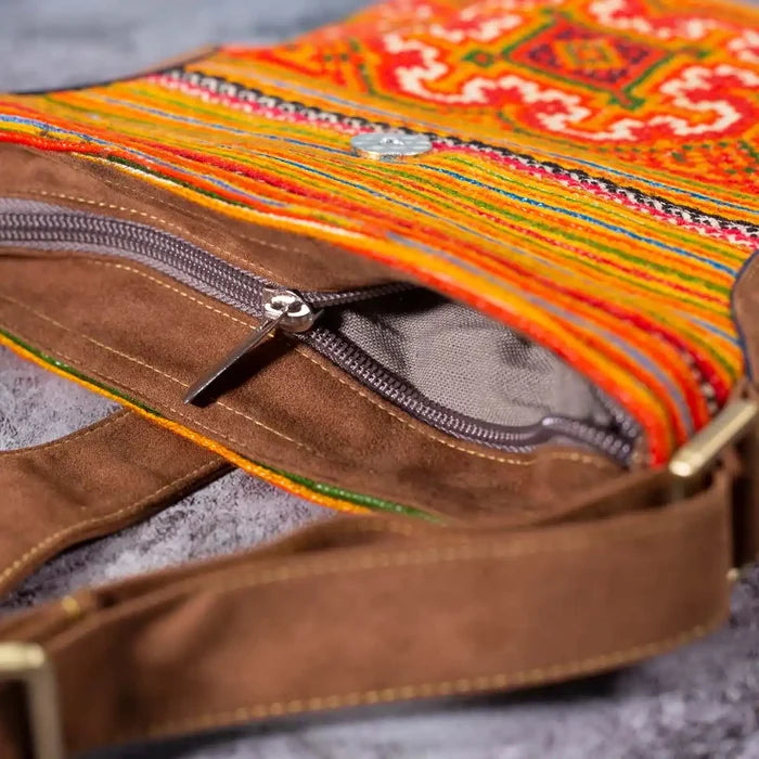 Vindigo orange hemp crossbody bag zipper and strap close-up with brown buckle