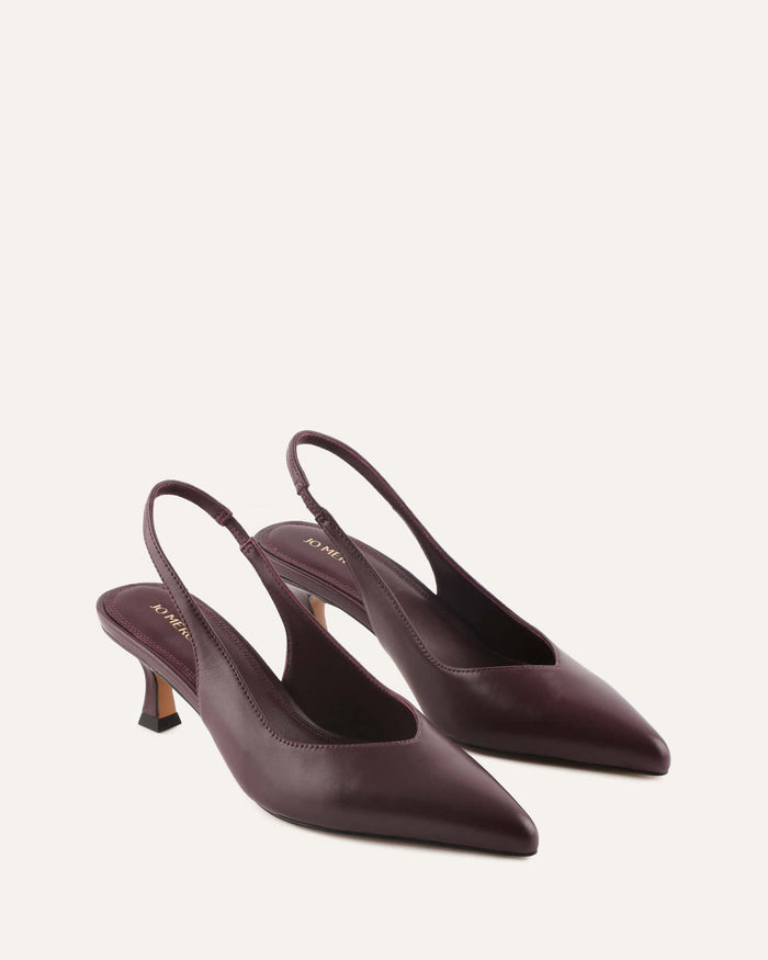 Pair of maroon high-heeled slingback shoes on a white background