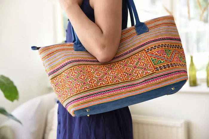 Vindigo tote bag made from orange striped floral border fabric carried by model