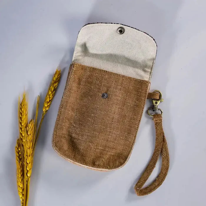 Open brown hemp flip phone belt bag with vintage patch, showing lining and button closure.