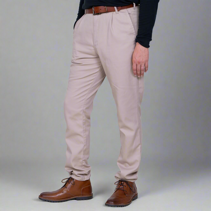 Person wearing beige pants and brown shoes on a plain background