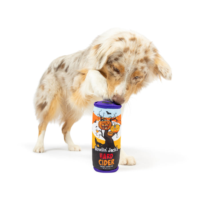 Dog playing with an orange can-shaped plush toy featuring Howlin' Jack's Hard Cider (Double Sided).