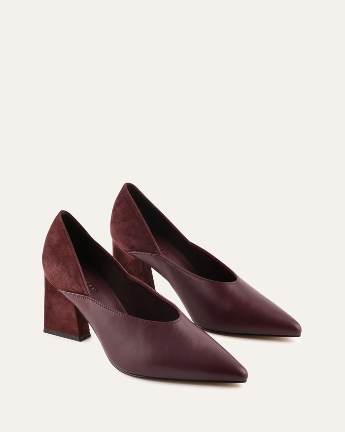 Pair of maroon high-heeled shoes on a light beige background