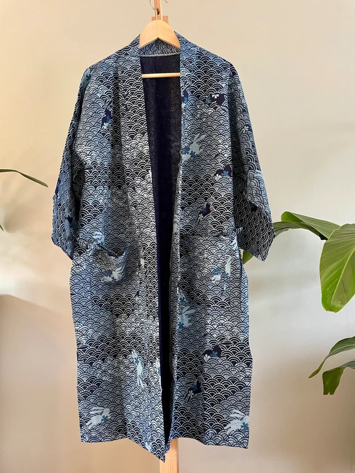 Blue patterned kimono on a wooden hanger against a neutral background