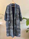 Blue patterned kimono on a wooden hanger against a neutral background