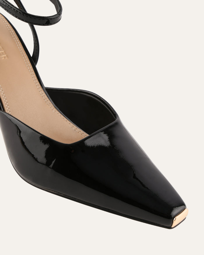 Black patent leather high heel shoe on a white background