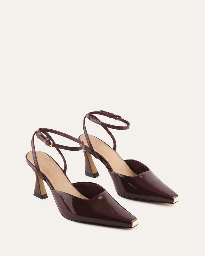 Pair of brown high-heeled shoes on a light beige background