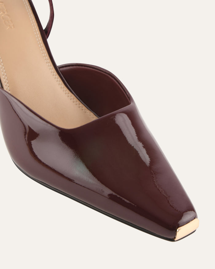 Brown high-heeled shoe with a pointed toe on a light gray background
