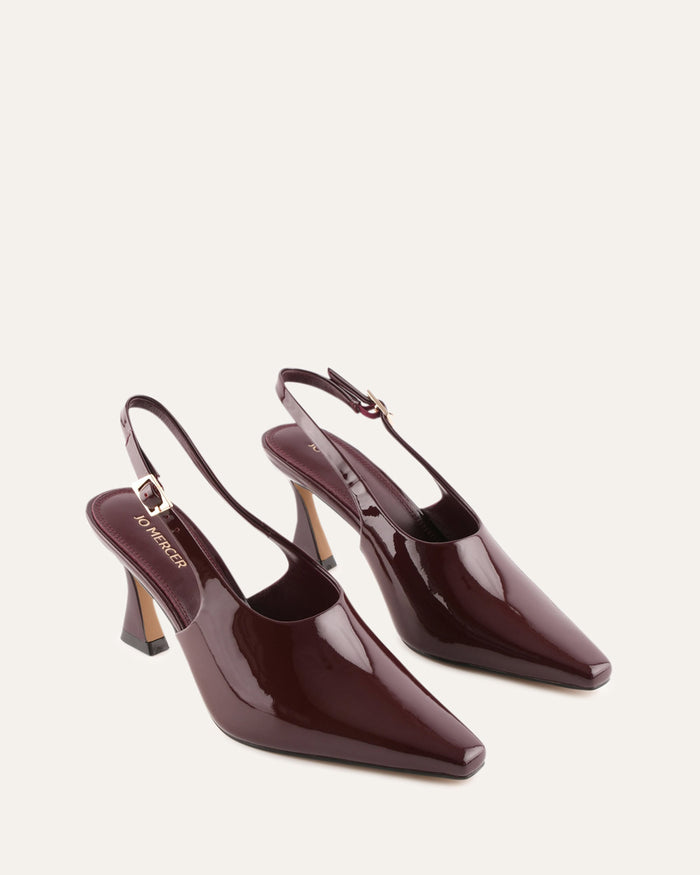 Pair of burgundy high-heeled shoes on a light beige background