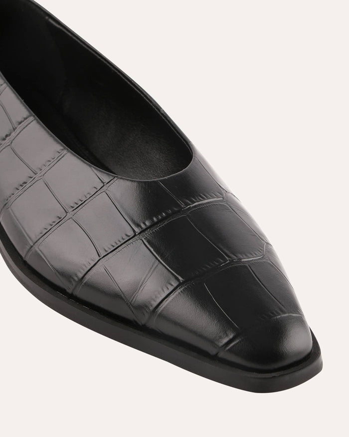 Black crocodile-patterned shoe on a light gray background