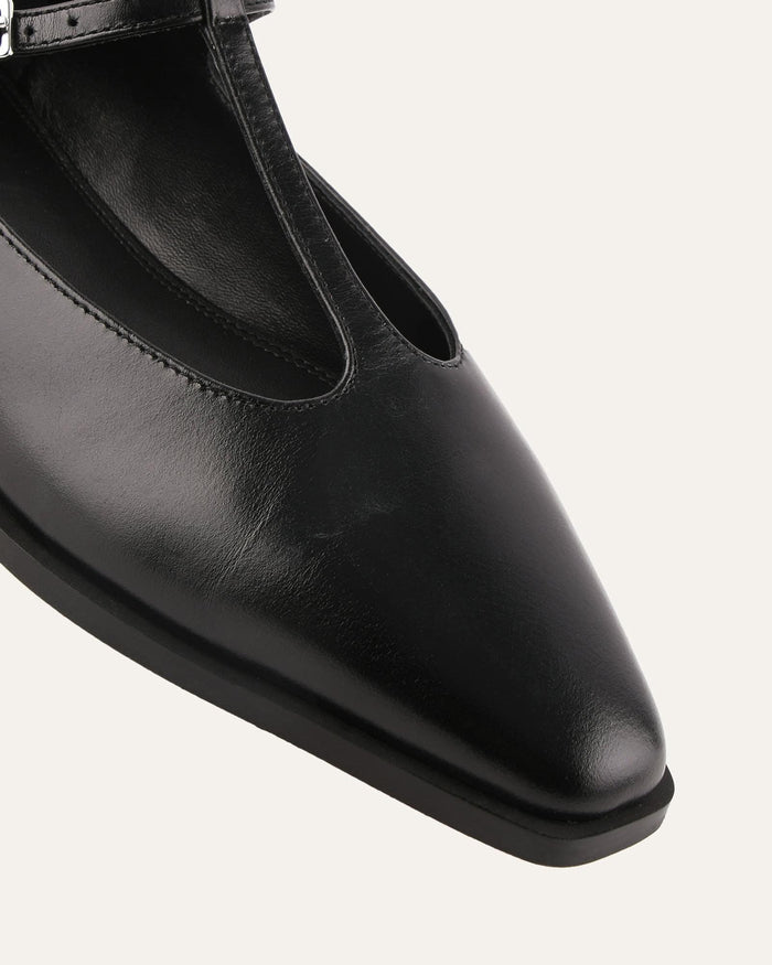 Black leather flat shoe on a light gray background