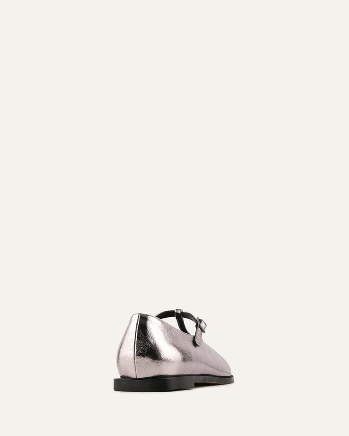 Silver shoe with a black sole on a white background