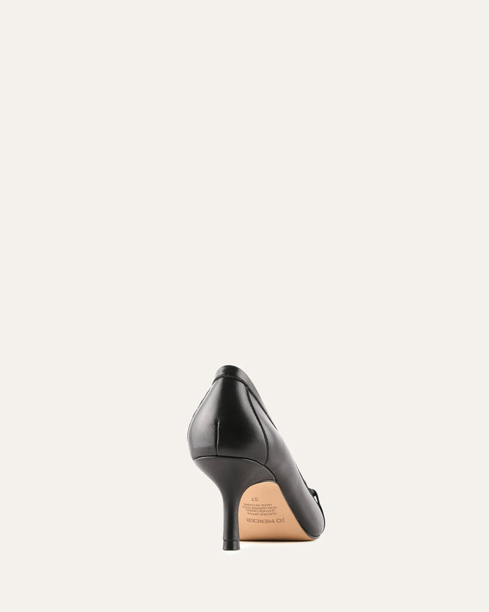 Black high-heeled shoe on a light beige background