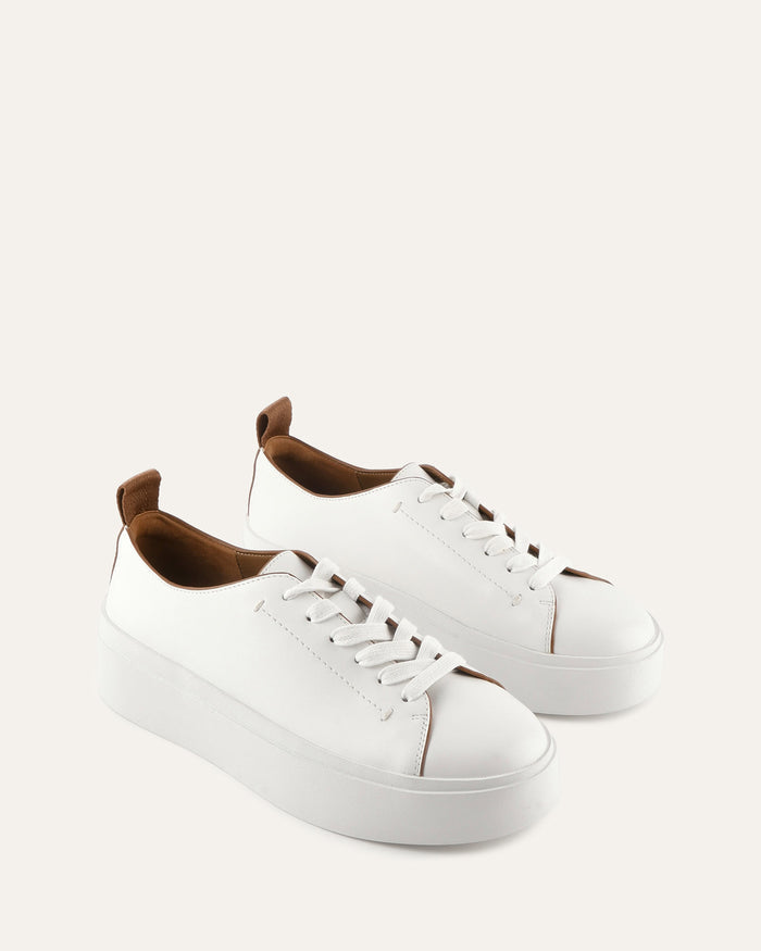 White sneakers with brown accents on a light gray background