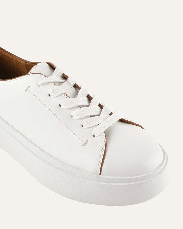 White sneaker with brown accents on a white background