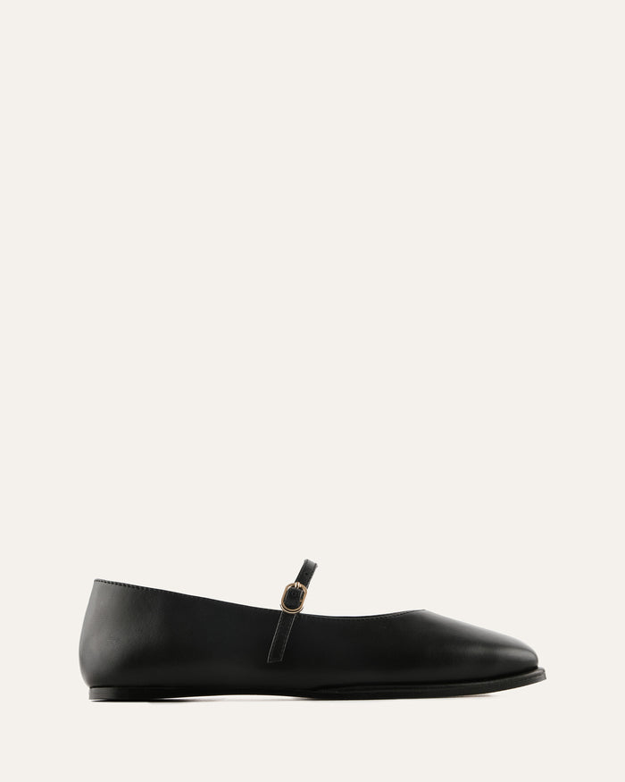 Black flat shoe with a strap on a white background