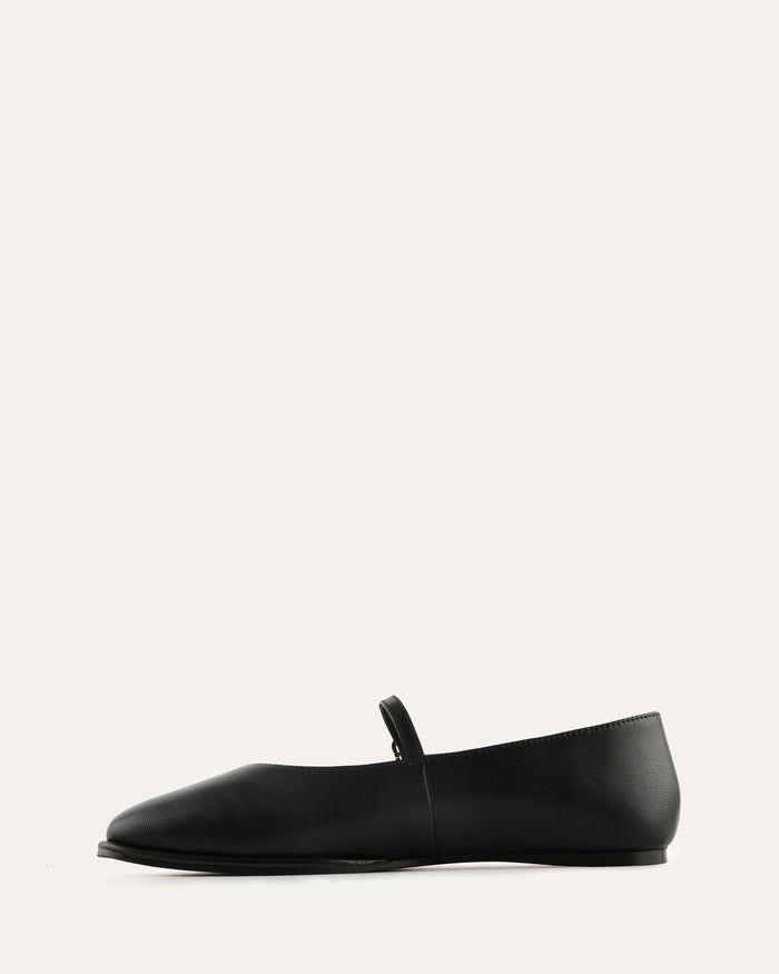 Brown perforated flat shoe on a light beige background