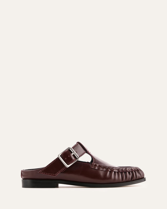 Brown loafer shoe with a buckle on a white background