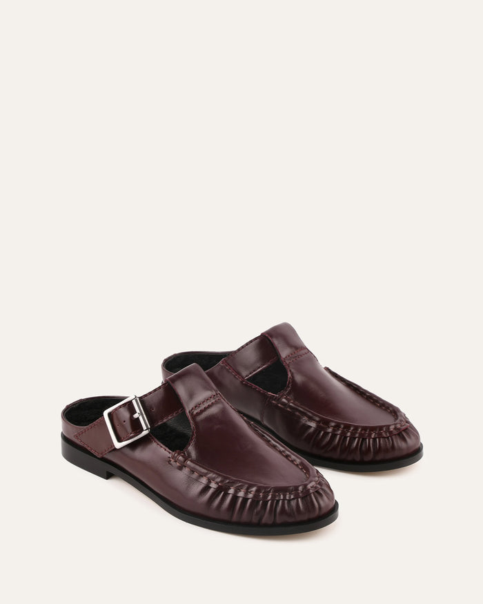 Pair of brown loafers with a buckle on a white background