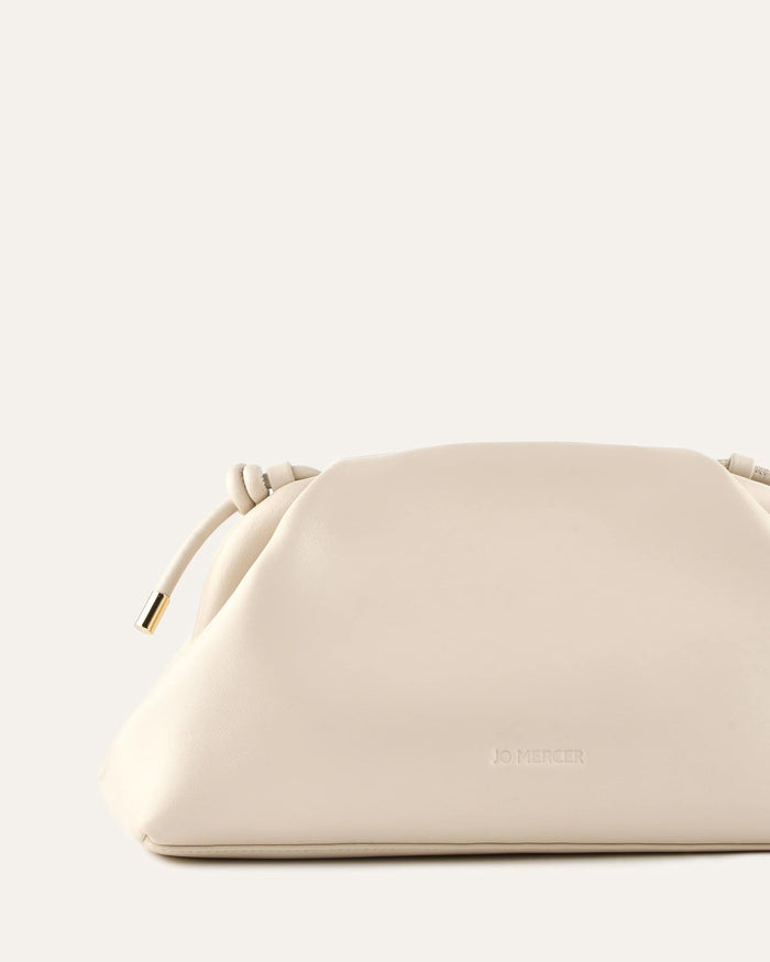Beige handbag with a brand logo on a light gray background