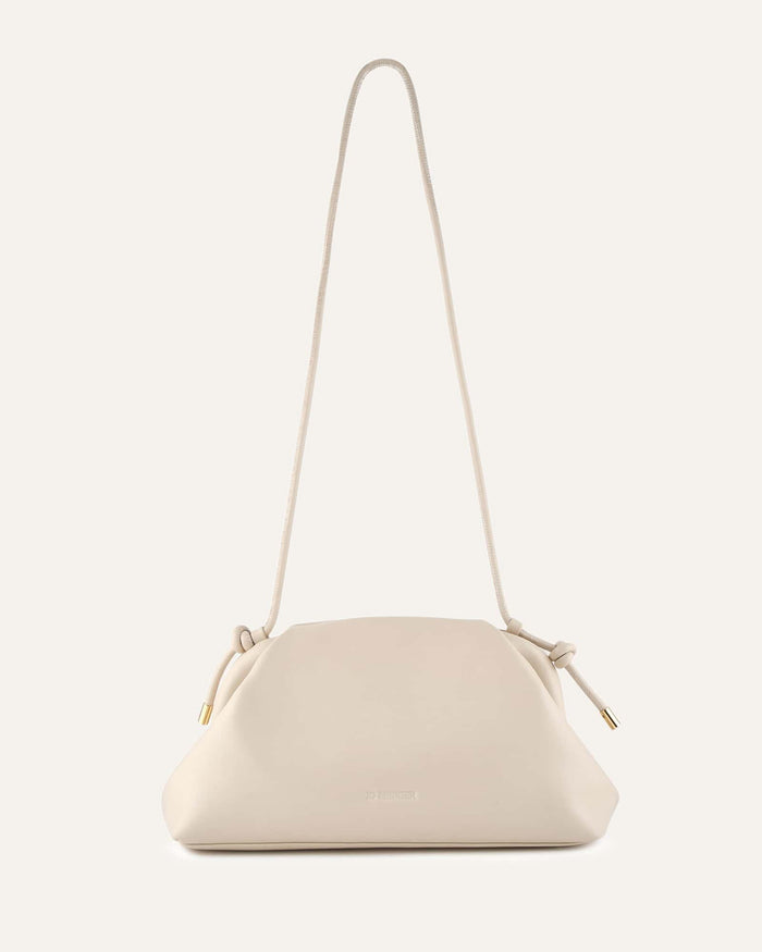 White handbag with a strap on a light beige background