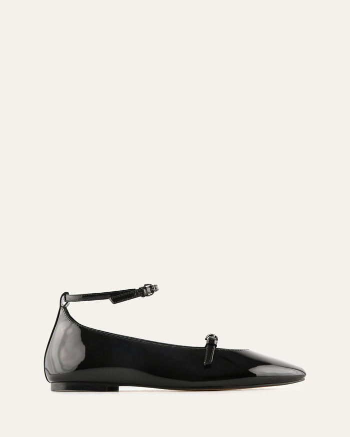 Black patent leather flat shoe with a thin strap on a white background