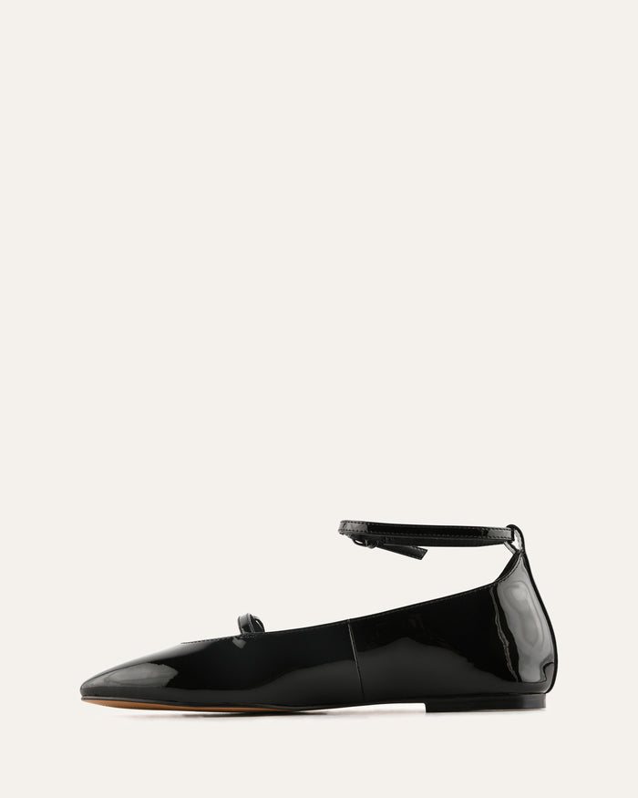 Black patent leather flat shoe on a white background